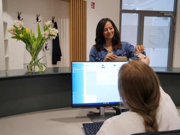 Patientin mit Helferin am Empfang