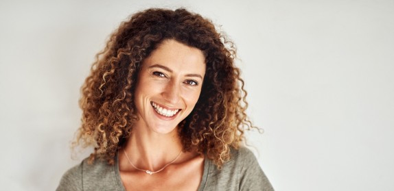 Frau mit Locken laechelt