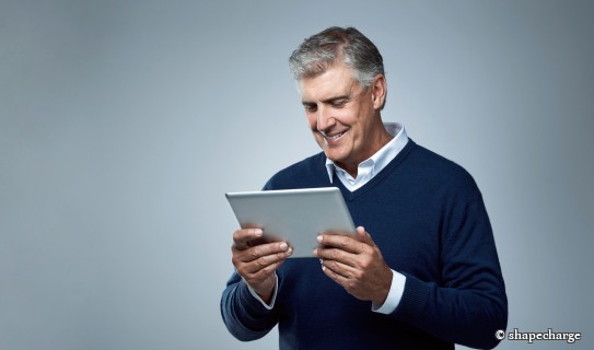 Mann laechelt auf Ipad